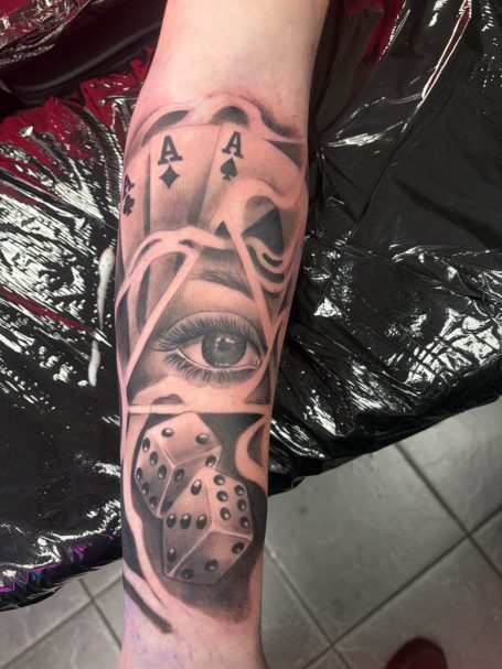 Black and grey gambling men’s tattoo